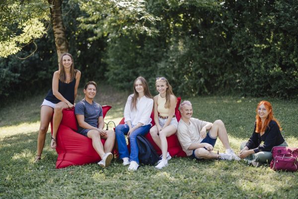 Studierendengruppe sitzend auf einer Wiese am Campus der Hochschule Landshut